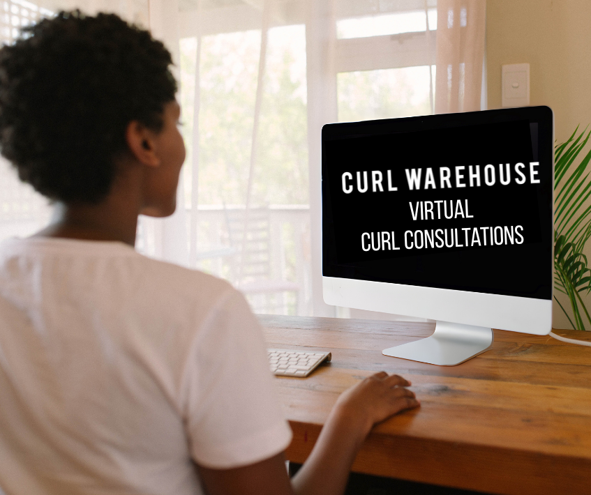 Person using a computer with 'Curl Warehouse Virtual Curl Consultations' on the screen at a desk.